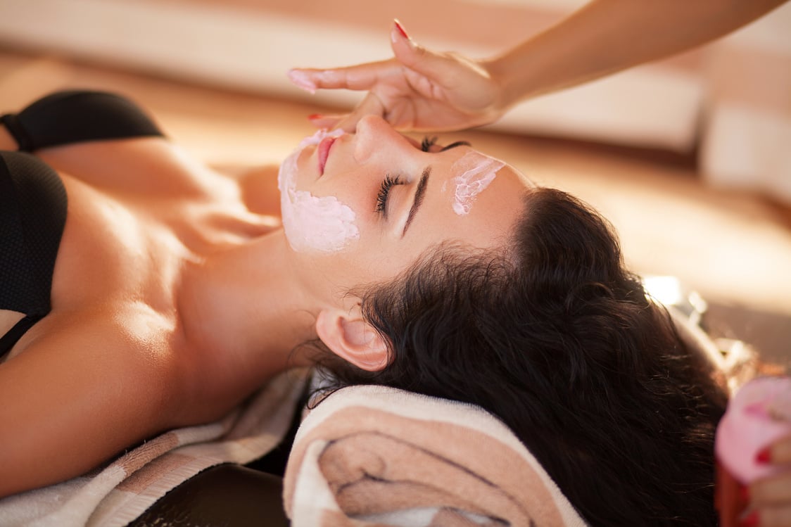 Professional Applying Facial Scrub in Young Woman's Face Inside Spa