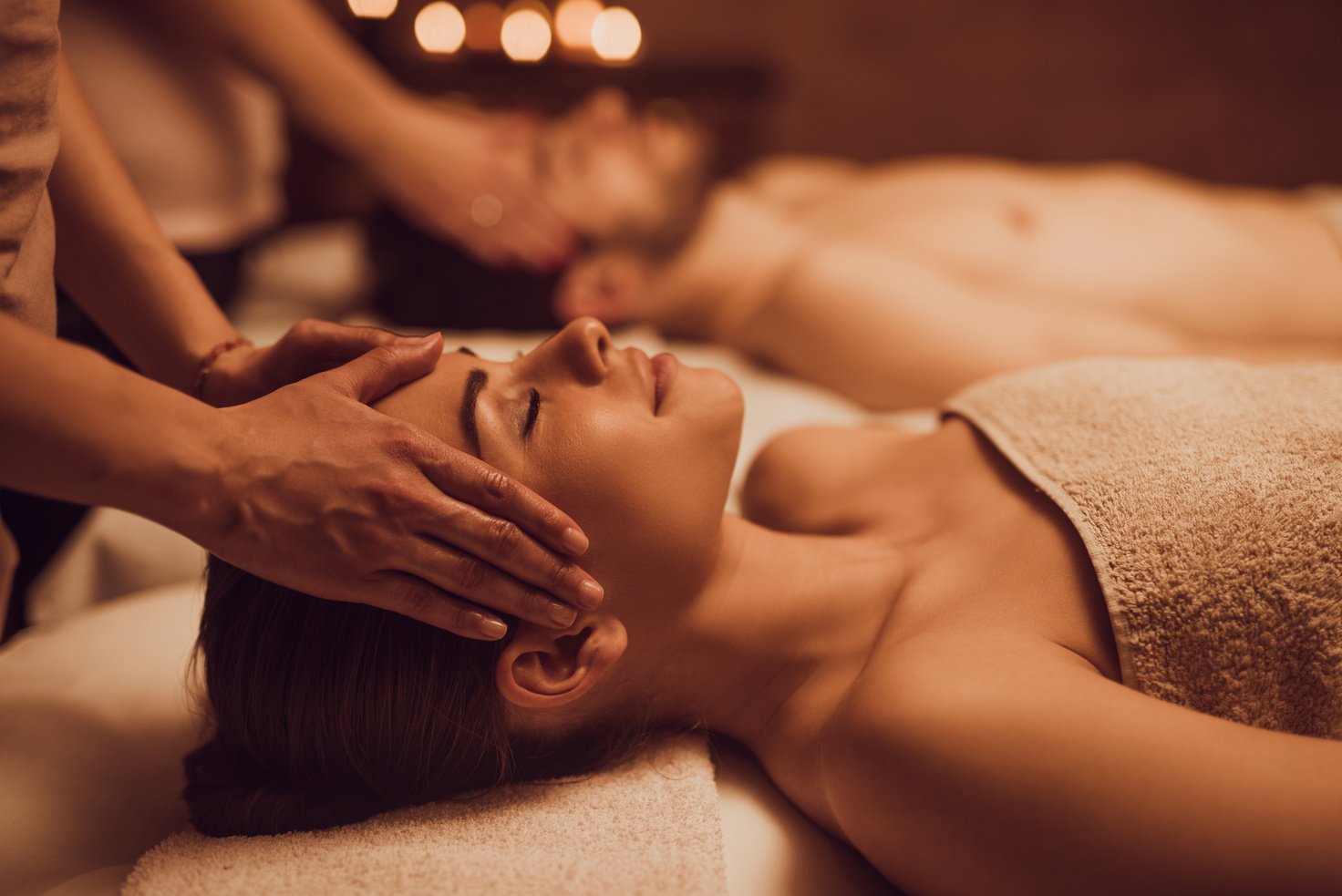 Young couple having relaxing head massage at beauty spa.